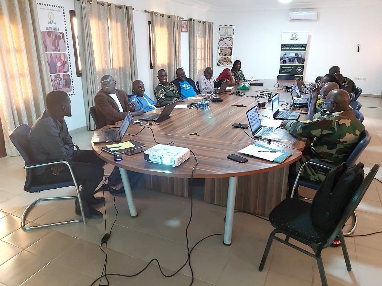 Formation au logiciel RH-ARSM à Dakar, en mars 2023 : participants en tenue militaire et civile autour d'une table, ordinateurs ouverts
